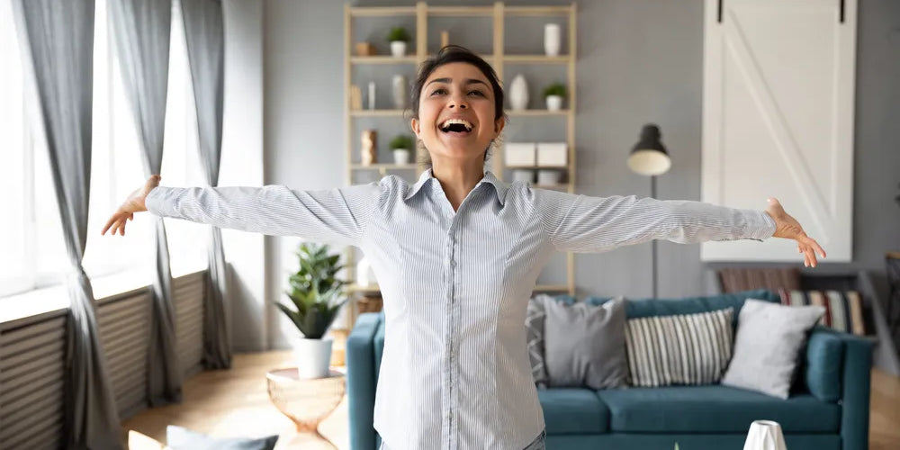 Lebensenergie gewinnen: Lachende Frau befreit sich von Erschöpfung, Arme ausgebreitet.