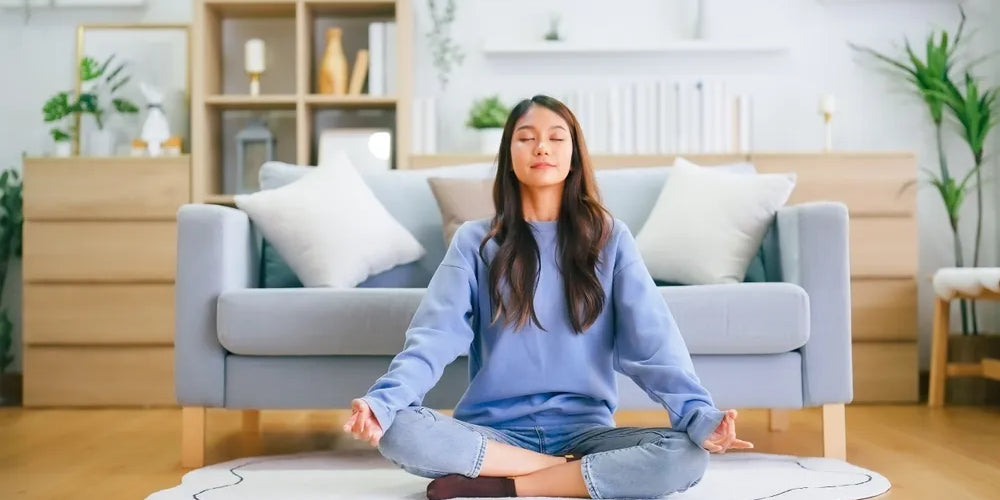 Frau meditiert im Lotussitz, um Körper, Geist und Seele in Einklang zu bringen.