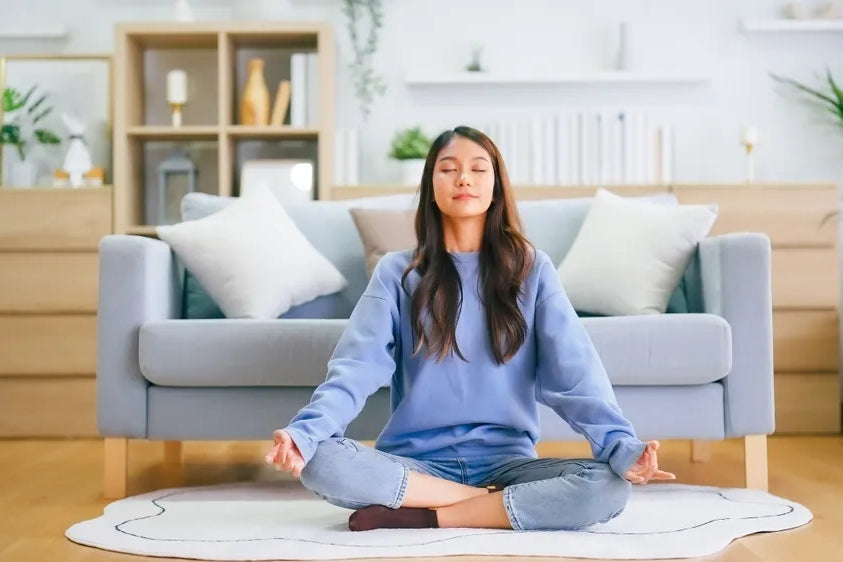Frau meditiert im Lotussitz, um Körper, Geist und Seele in Einklang zu bringen.