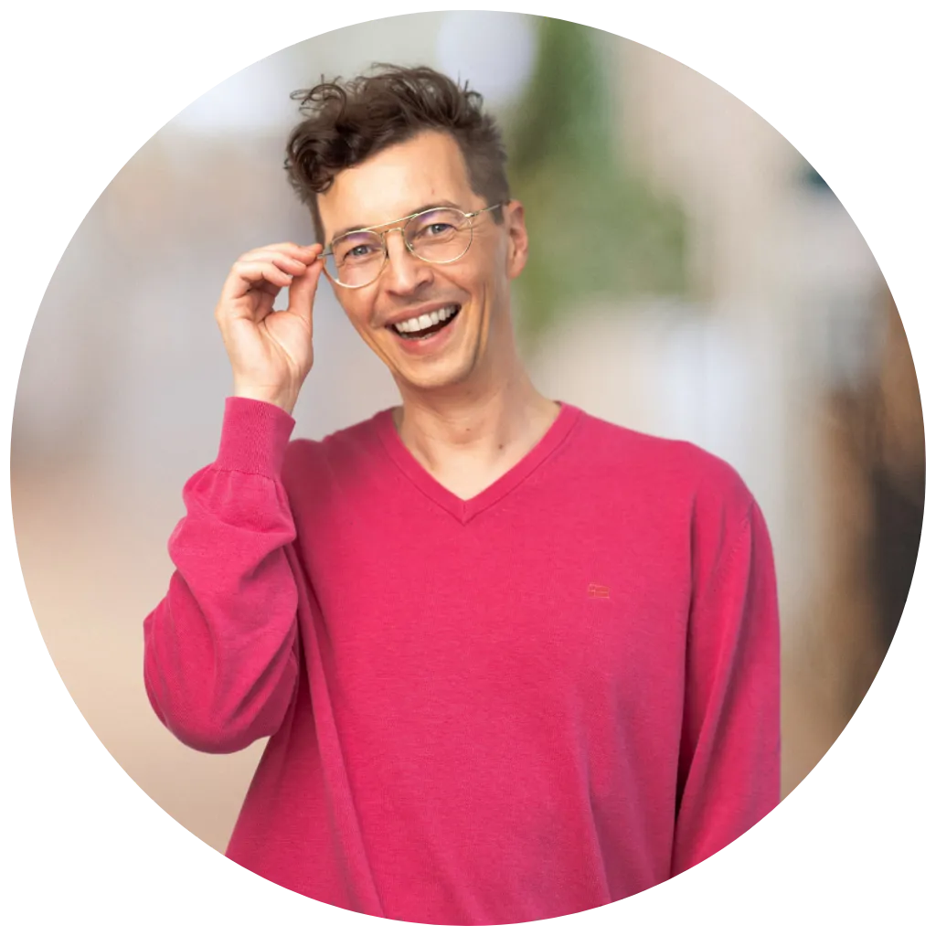 Benedikt Heiming, Creative Director und Podcast Host, lächelt in pinkem Pullover.